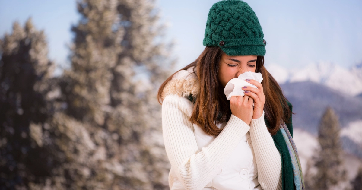 Woman with wonter sniffles in the snow